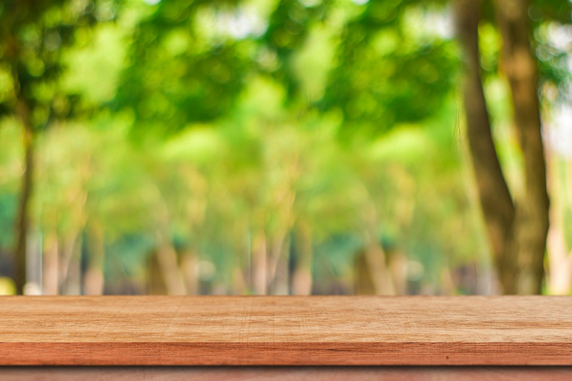 Empty wood table for product display over blur green tree garden