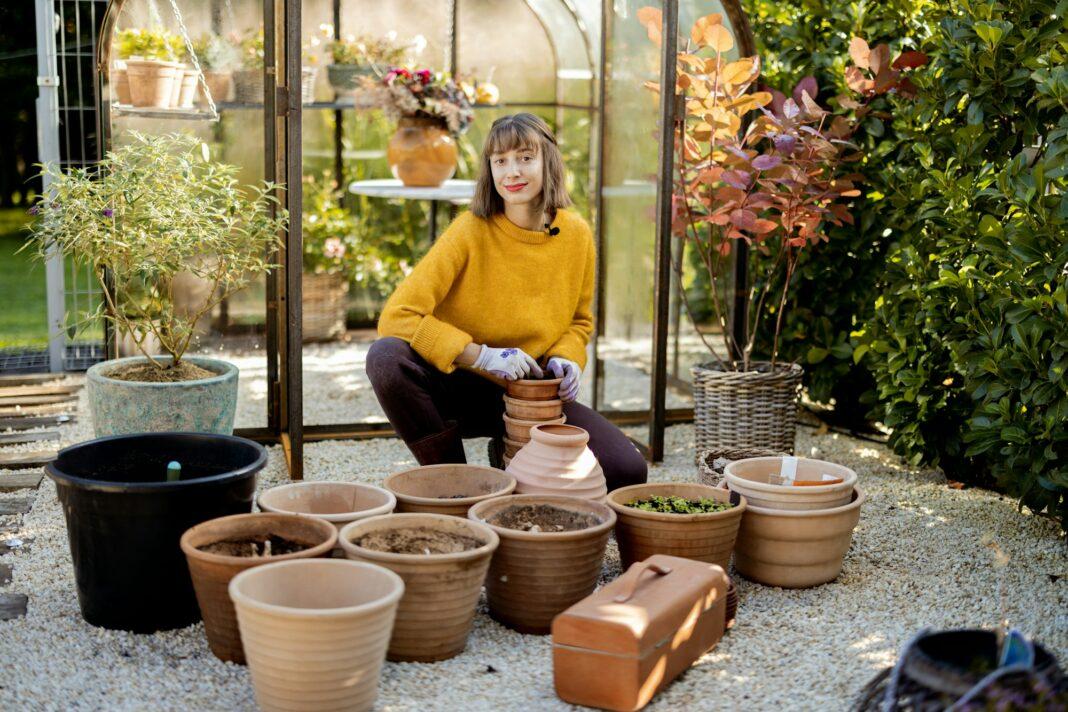 Woman planting flowers in jugs at garden